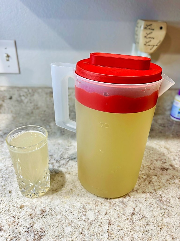 a pitcher and glass of lemonade